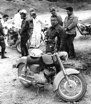 imagem do criador da empresa yamaha, ao lado de sua moto, em preto e branco